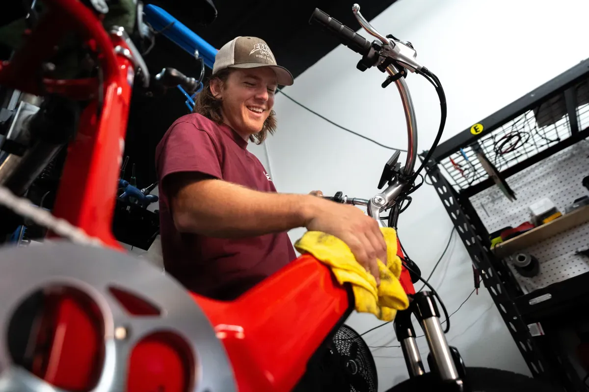 Chase repairing a red e-bike